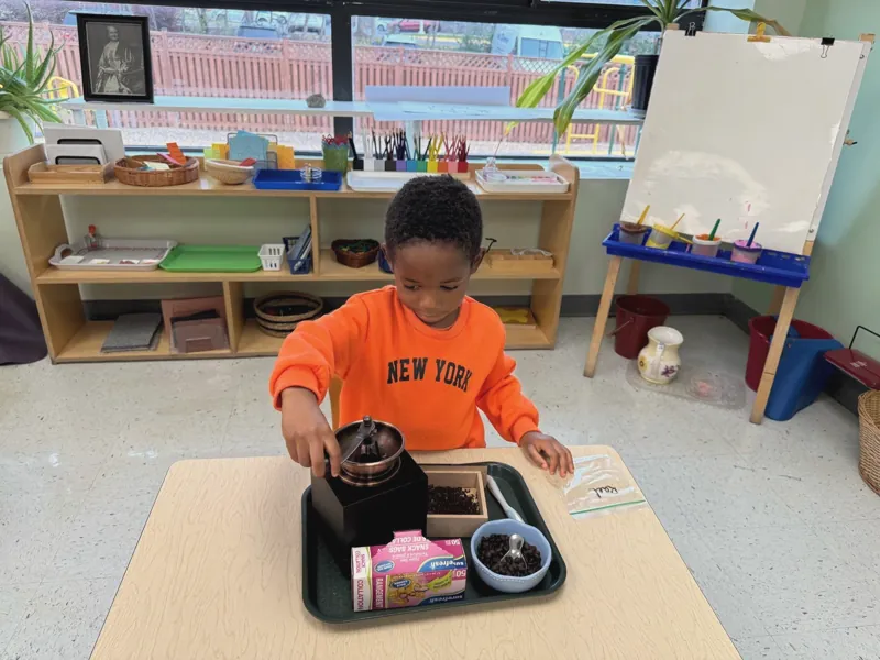 A boy pouring at a child-sized table